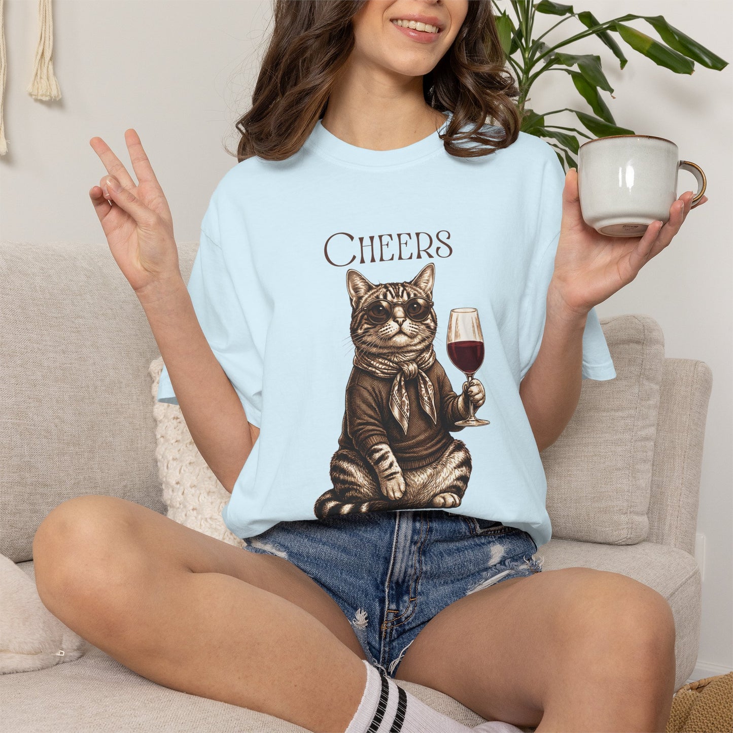 Unisex t-shirt featuring a vintage style graphic of a cat wearing a scarf and holding a glass of wine with the text Cheers.